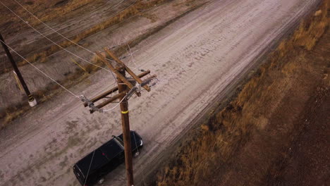 suv parked on a dusty road under the power line, moreno valley upland game hunting area, aerial overhead shot