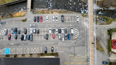 Vista-Superior-Del-Siguiente-Remonte-En-Góndola-Sobre-El-Río-Y-Estacionamiento-En-La-Estación-De-Morzine,-Francia