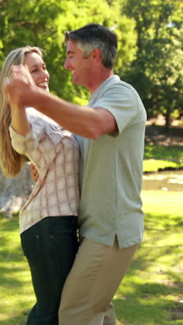 una pareja feliz bailando en el parque.