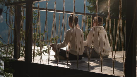 couple enjoys sunrise meditating at glamping. relaxed yoga lovers seek mind harmony at luxury eco resort. woman and man sit in lotus poses outdoors