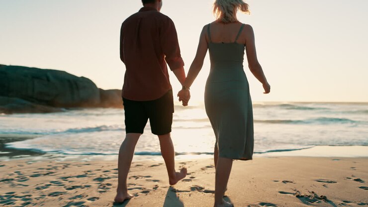 Plage, dos et couple se tenant la main en marchant