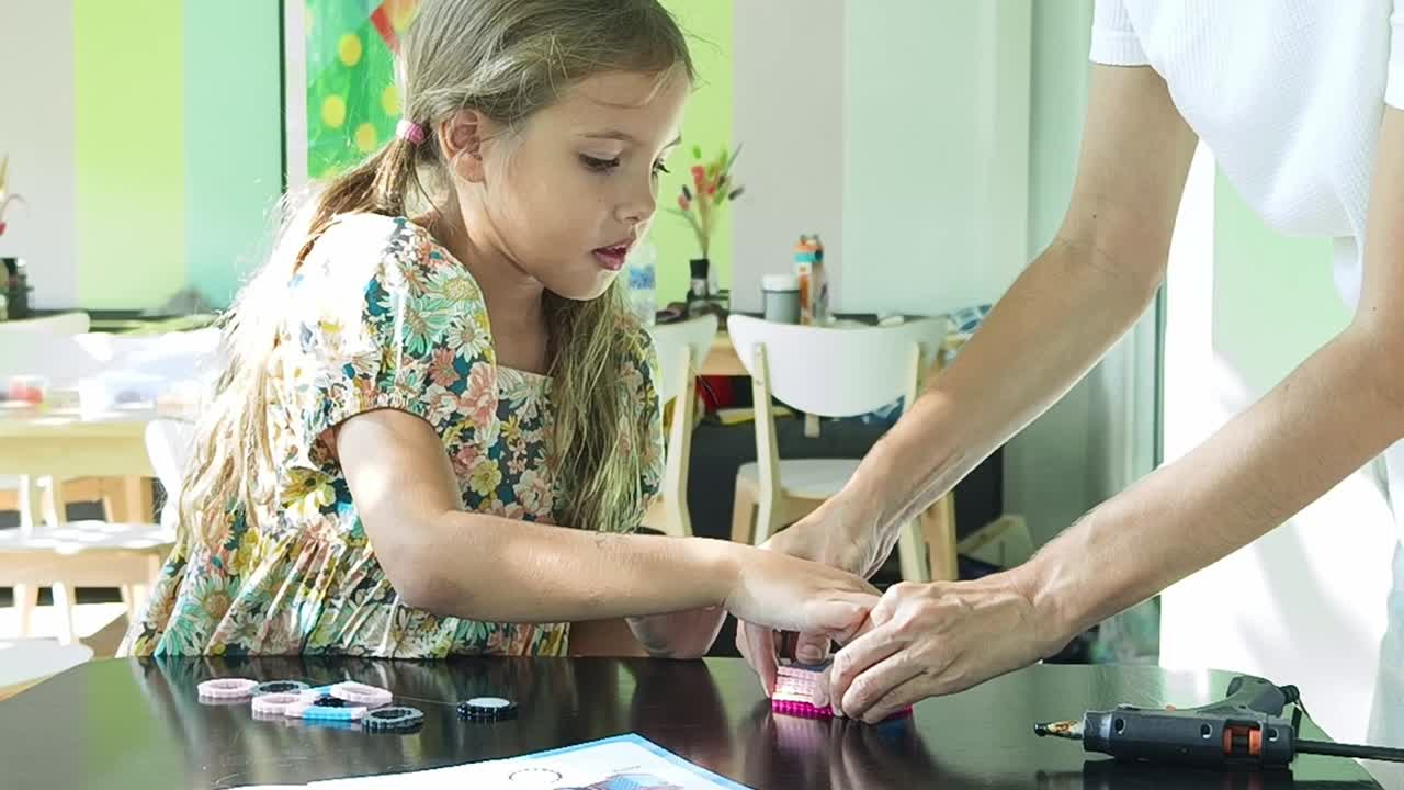 niña y madre haciendo artesanía juntos