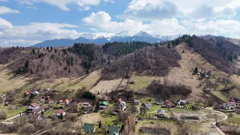 a picturesque village nestled in the mountains under a bright blue sky with fluffy white clouds