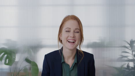 portrait young happy red head business woman laughing enjoying successful corporate lifestyle running hand through hair slow motion