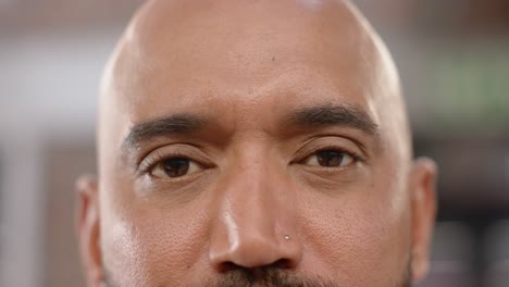 portrait close up of eyes of biracial creative businessman smiling in office, in slow motion