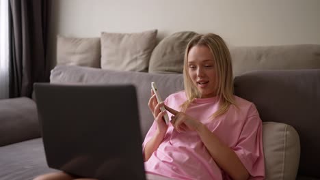 teenage girl using laptop and smartphone at home