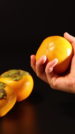 manos interactuando con persimmon en fondo oscuro