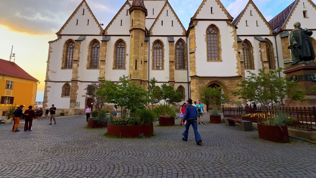 Sibiu, Romania, 17 July 2025: Statue and Lutheran Cathedral in Sibiu. A bronze statue in front of the Lutheran Cathedral in Sibiu with people around