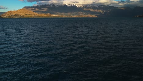 Lake-Wakatipu-Mit-Schneebedeckten-Bergen-Und-Dicken,-Langen,-Grauen-Wolken-In-Der-Ferne