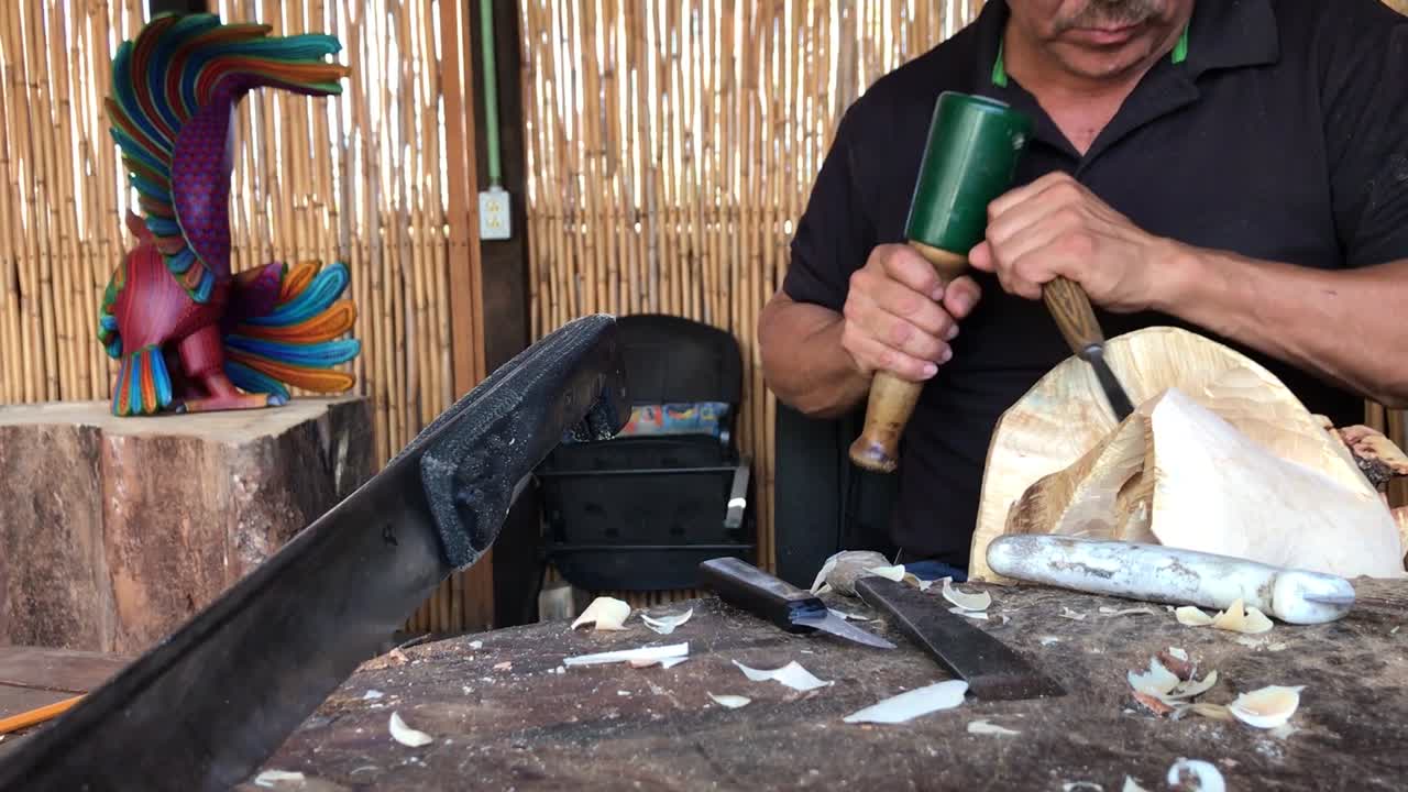 A craftsman creating a wood sculpture in his workshop.