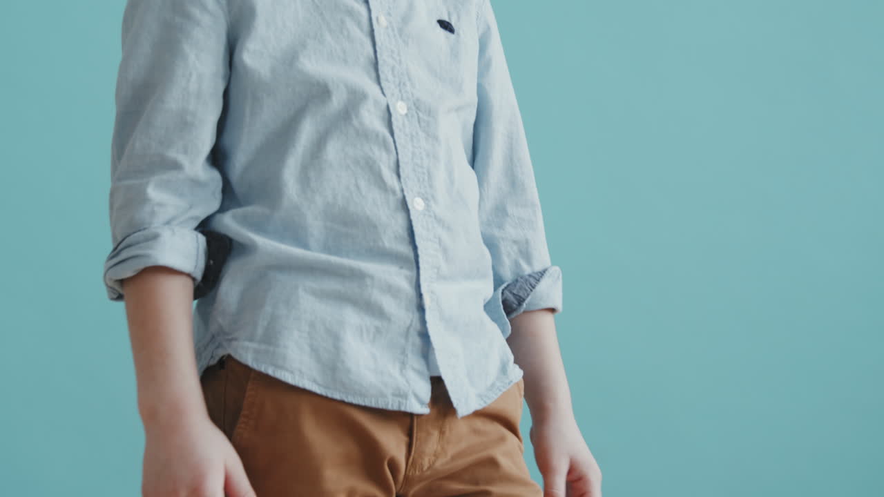 6-Year-Old Boy Posing Against Blue Background