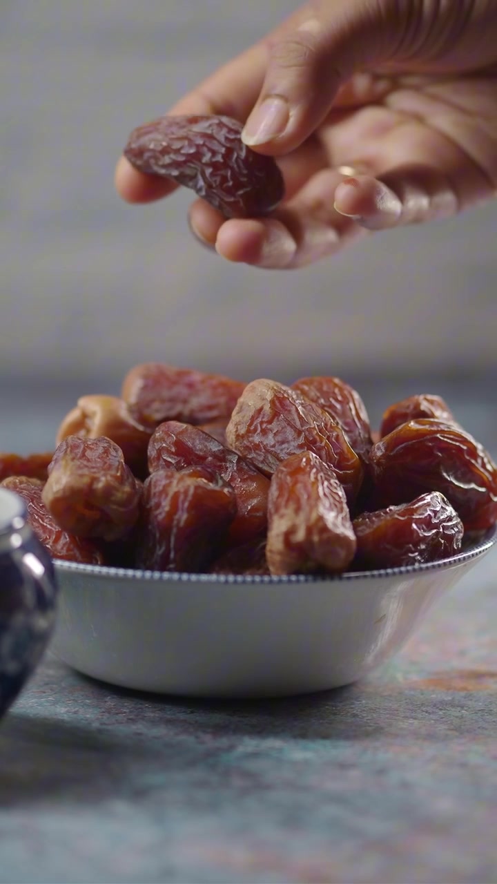 Hand Picking a Sweet Date from a Bowl