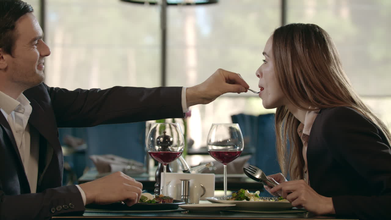 Bell'uomo che imbocca la donna a una cena romantica. Coppia che cena a un appuntamento romantico.