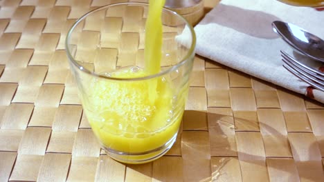 Orangensaft-In-Ein-Glas-Gießen,-Das-Morgendliche-Frühstück.-Zeitlupe-Mit-Rotierender-Kamerafahrt.