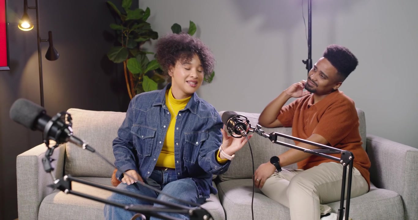 African American guests reacting to host gesturing, grabbing mic, joining discussion in studio