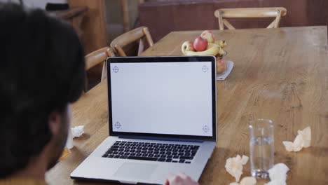 Caucasian-man-holding-medication-making-video-call-using-laptop,-copy-space-on-screen,-slow-motion