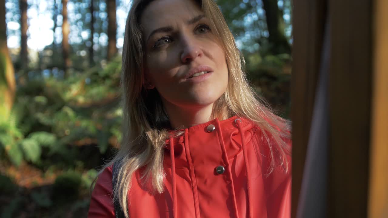 hermosa mujer leyendo un letrero de información del sendero forestal