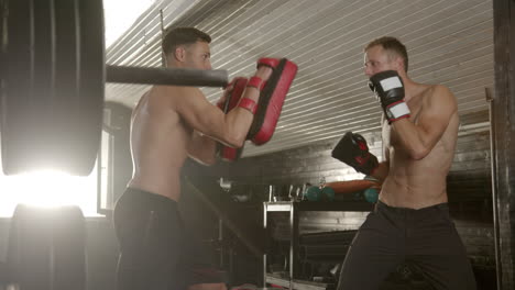 two men boxing training in a gym