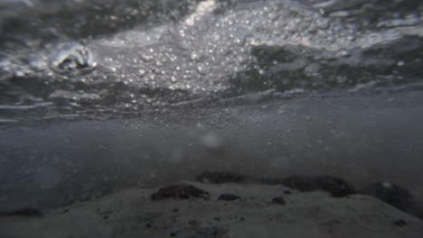 water level view of waves crashing and rolling into shore in slow motion
