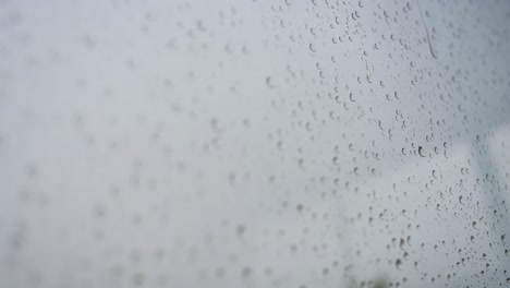 Blick-Auf-Regentropfen,-Die-Bei-Starkem-Regen-Auf-Einem-Fensterglas-Landen