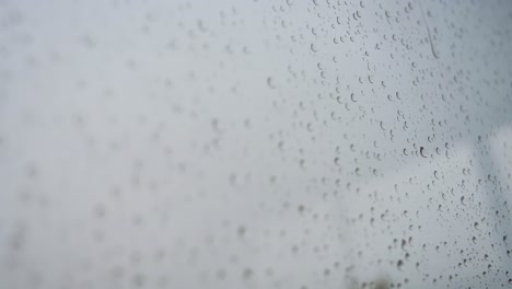 view of raindrops landing on a window glass during heavy rainfall