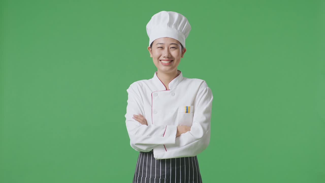 Asian Woman Chef Smiling And Crossing Her Arms To Camera While Standing In The Green Screen Background Studio