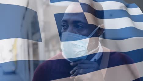 greek flag waving against man wearing face mask
