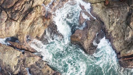 aerial cinematic view waves crushing rocks top view, waves and ocean