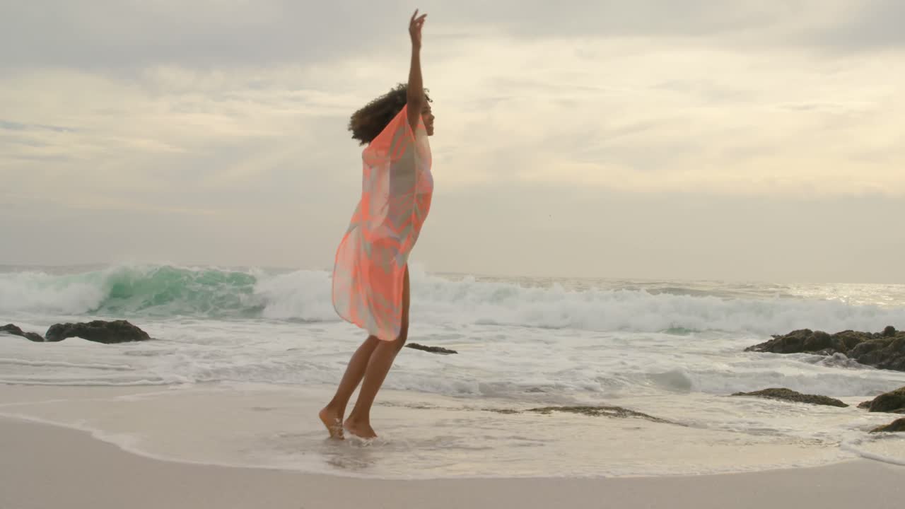아름다운 혼혈 여성이 해변에서 회전하고 있습니다.