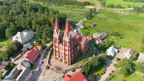 majestic tall church in small township of sveksna, lithuania, aerial orbit view