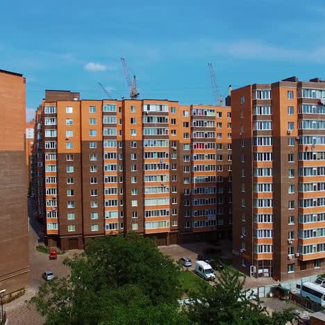 new high buildings in the city. residential apartments under the blue sky. architecture in brown colors in the modern district. camera rising up.