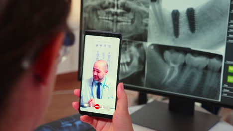 close up of assistant having videocall with specialist stomatologist