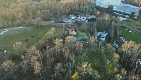 beautiful aerial of a small and remote farming town surrounded by forests in rural sweden