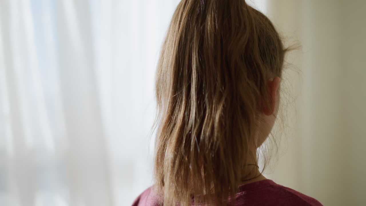 Close-up of girl walking toward her brother sleeping on a couch, gently covering him with a blanket, natural light filters through the window, creating a calm and caring atmosphere