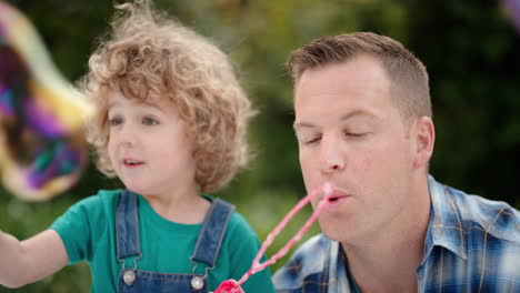 Vater-Und-Sohn-Blasen-Gemeinsam-Seifenblasen-Im-Sonnigen-Park.-Süßer-Kleiner-Junge,-Der-Spaß-Hat.-Vater-Spielt-Mit-Kind-Und-Genießt-Spielerisch-Den-Sommer-4k