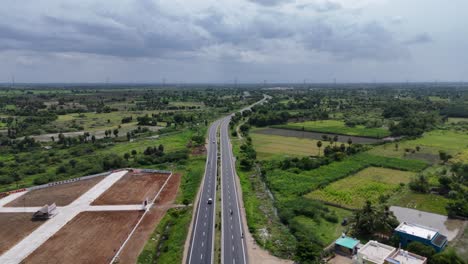 aerial view of a highway cutting through lush green countryside in india