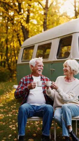 senior couple enjoying coffee outdoors by retro van