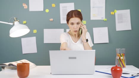 woman using laptop nervously talking on the phone.