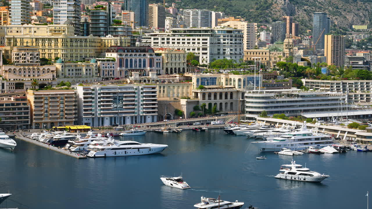View of boats docked in the Monaco Marina with the skyline of the city on the background