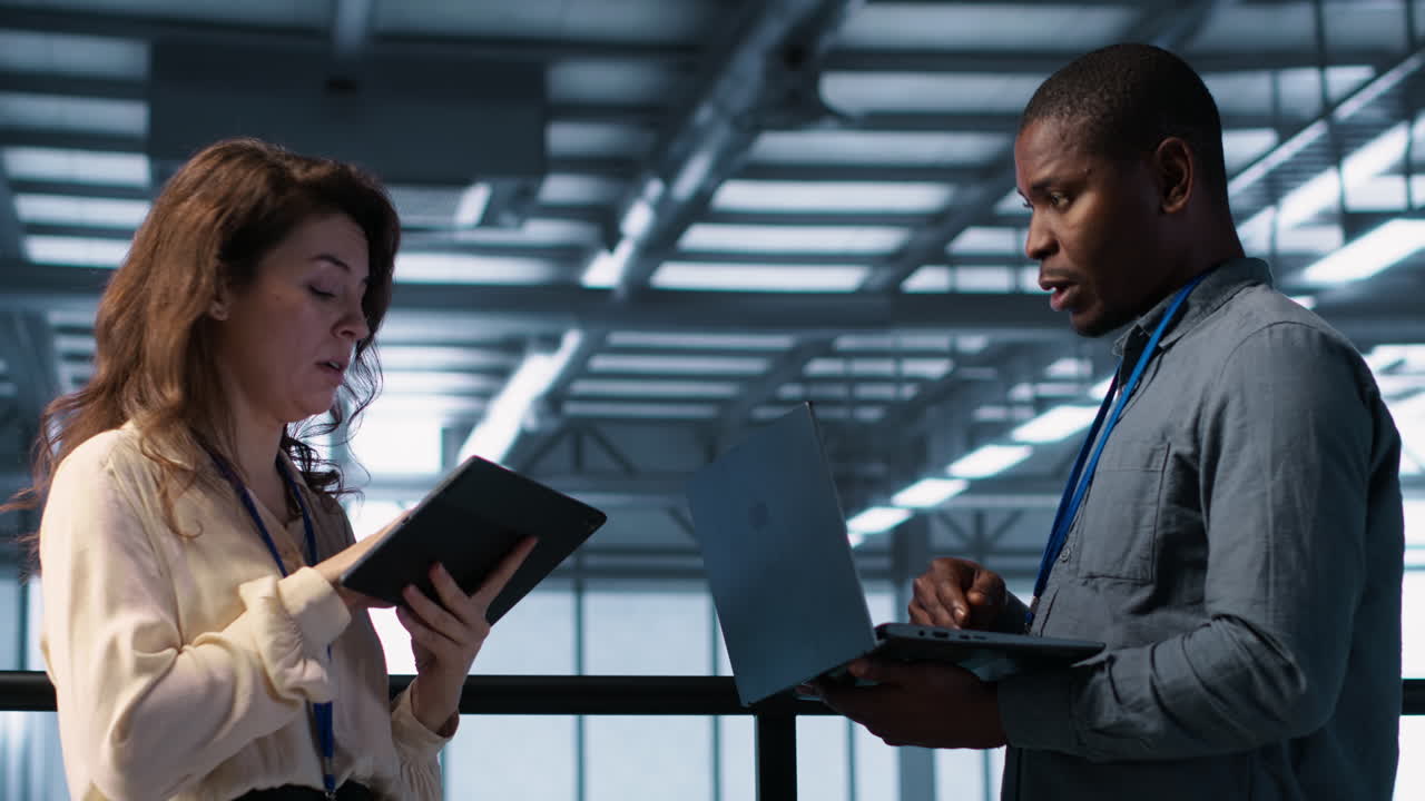 Colleagues in data center workplace use laptop to calibrate energy usage