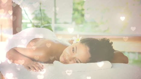 mujer relajándose y acostándose en el spa con corazones para el día de san valentín