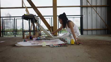woman artist painting on the floor in an urban studio