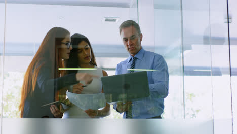 Business-colleagues-discussing-over-laptop-and-document-4k