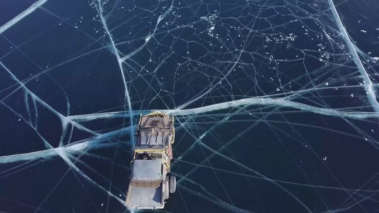 Drone jagter fremad over hjemmebyggede biler på en isbelagt sø i Rusland.