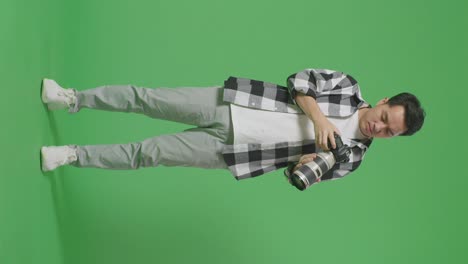 man adjusting and celebrating with camera in studio