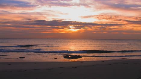 las olas de la playa se rompen lentamente durante la puesta de sol 1