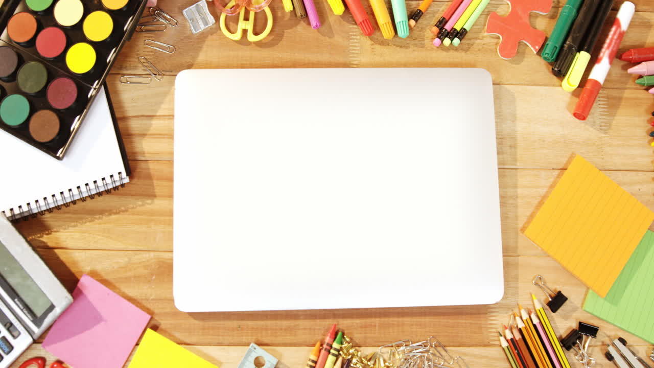 primer plano de una computadora portátil con varios artículos de papelería