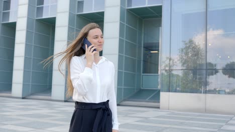 feliz mujer de negocios nórdica: conversaciones telefónicas fuera de la oficina, sonriendo y riendo