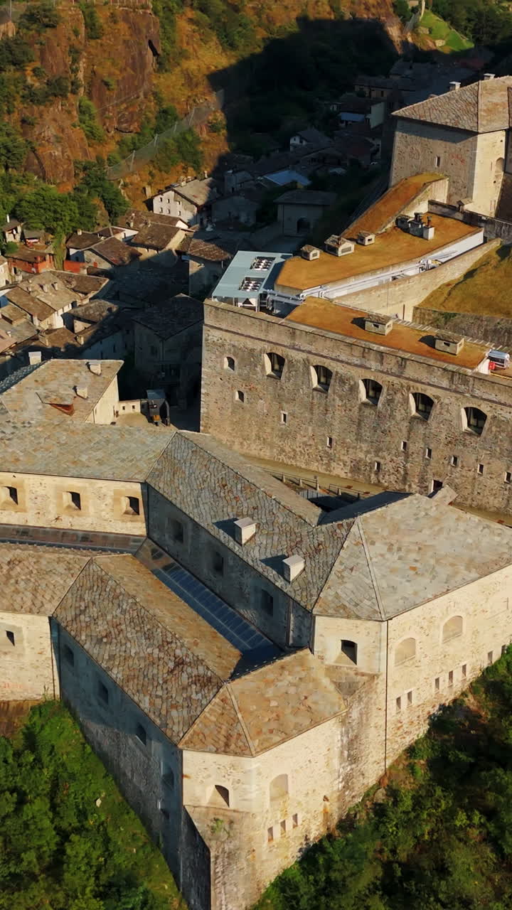 Panoramica aerea verticale dell'architettura medievale in pietra del Forte di Bard in Valle d'Aosta, Italia.
