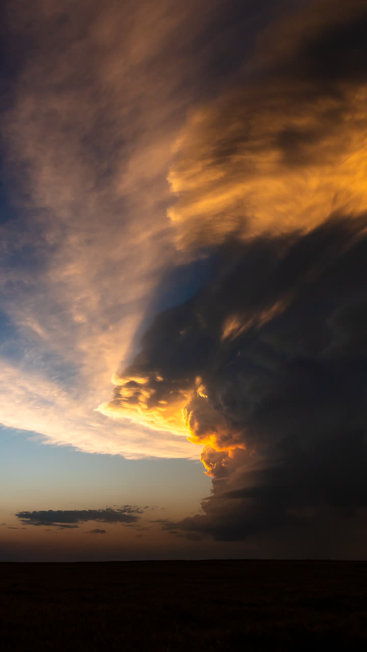 Storm clouds lit by sunset colors over wide open sky with dramatic light and textured cloudscape